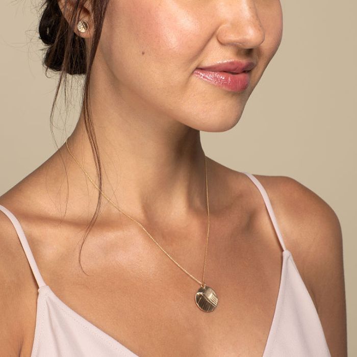 Model wearing 14K gold mountain necklace with diamond moon