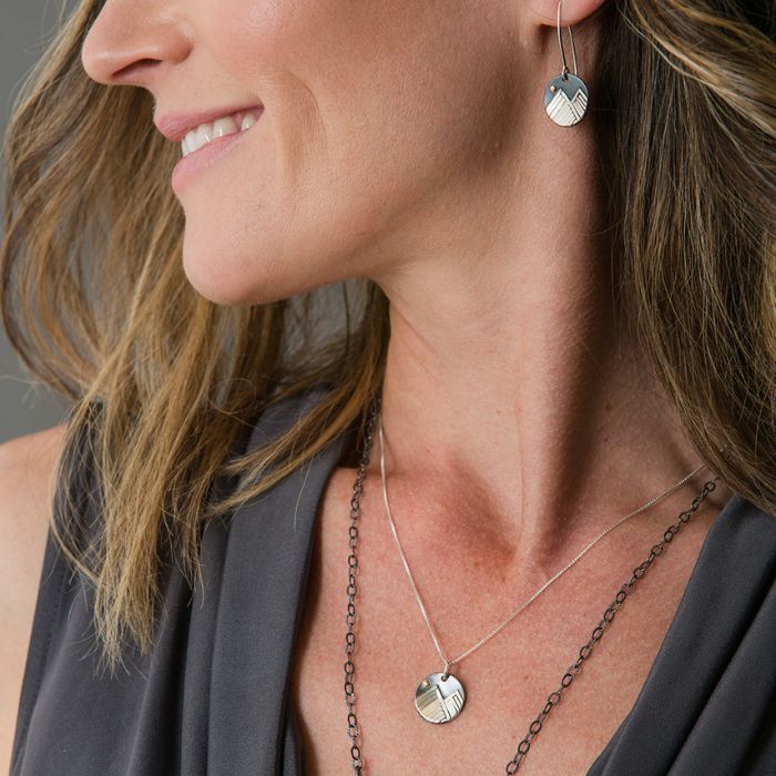 Model wearing silver mini mountain necklace