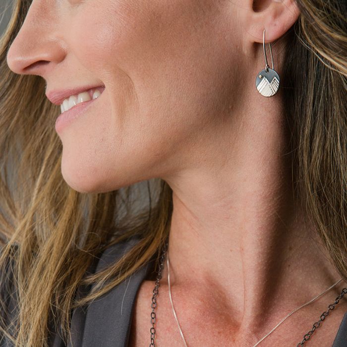 Model wearing silver mountain dangle earrings