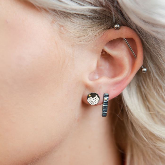 Model wearing silver and gold mountain stud earrings