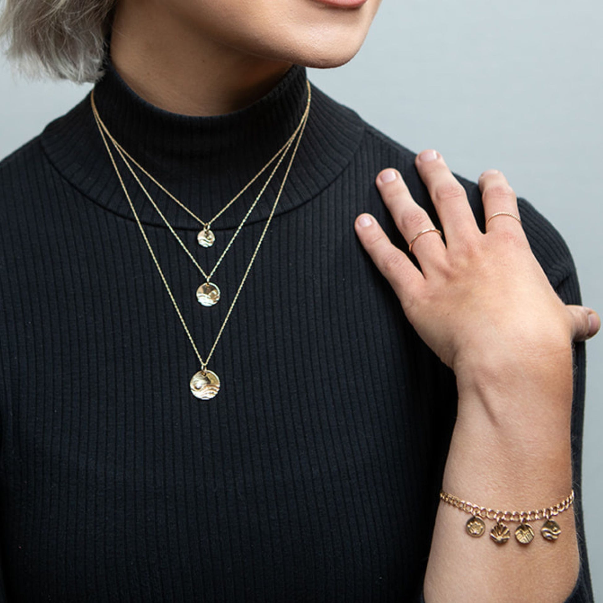 Model wearing gold reflections charm