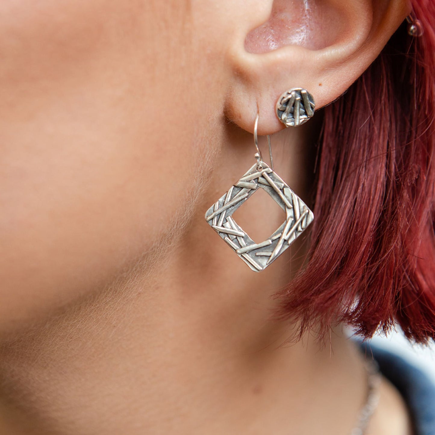 Square washer earrings close up on model