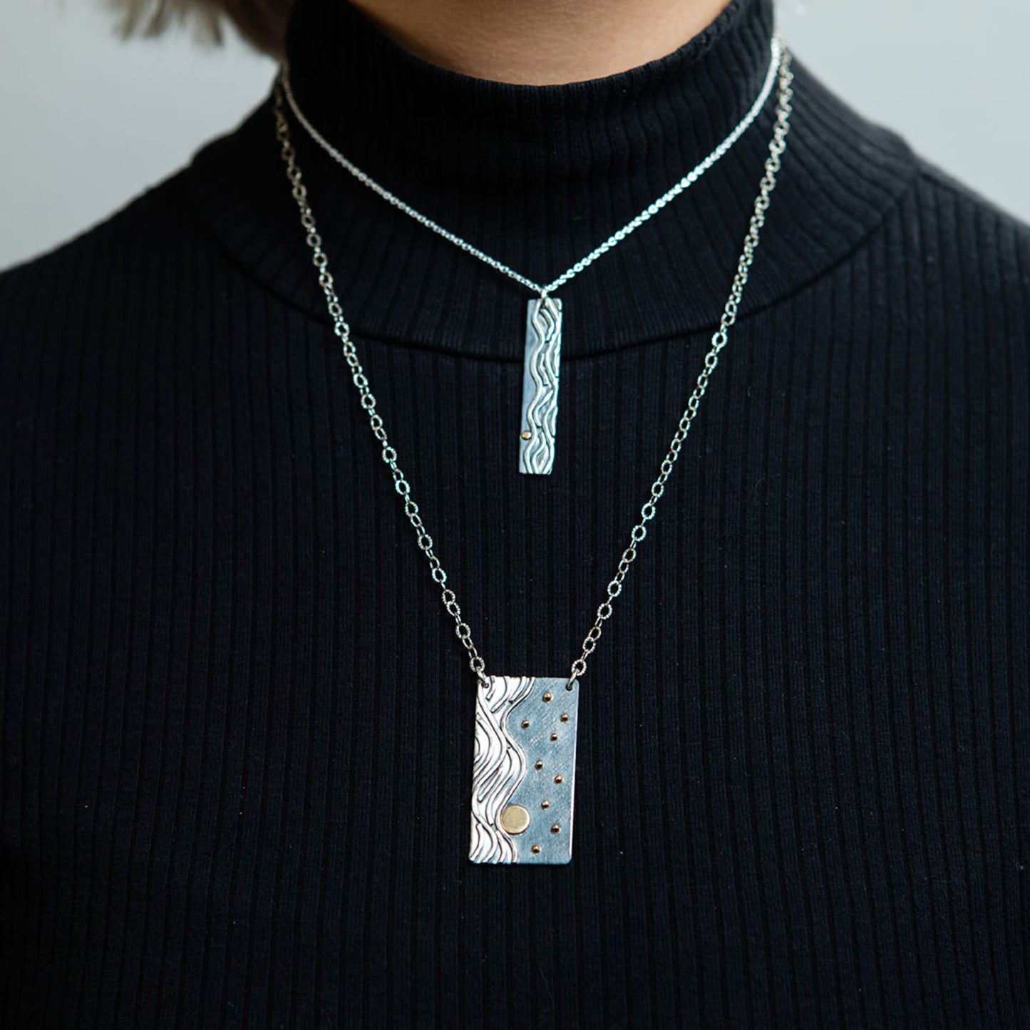 Closeup of model wearing Reflections necklaces