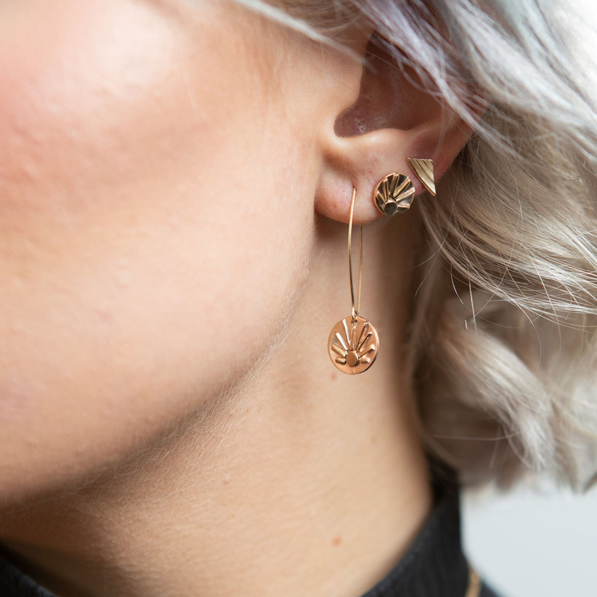 Closeup of model wearing gold shine earrings