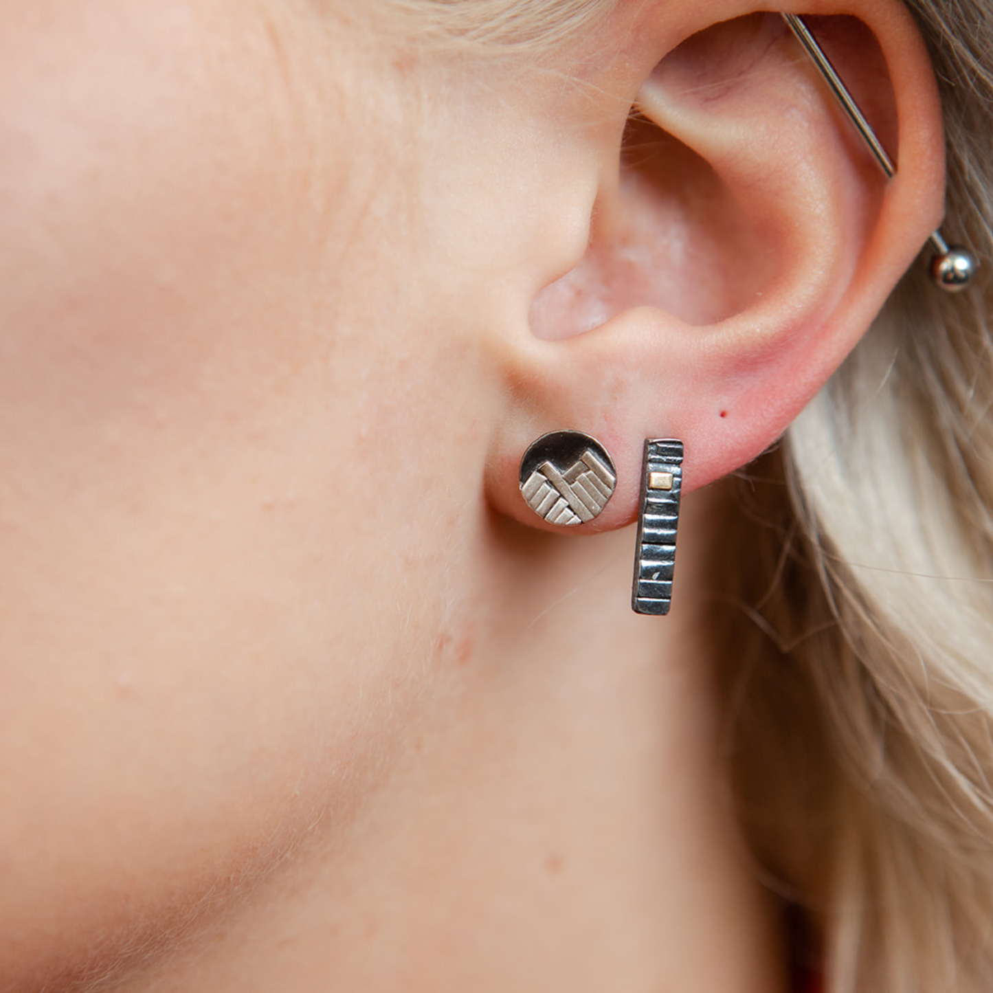 Closeup of model wearing oxidized mixed metal bar earrings