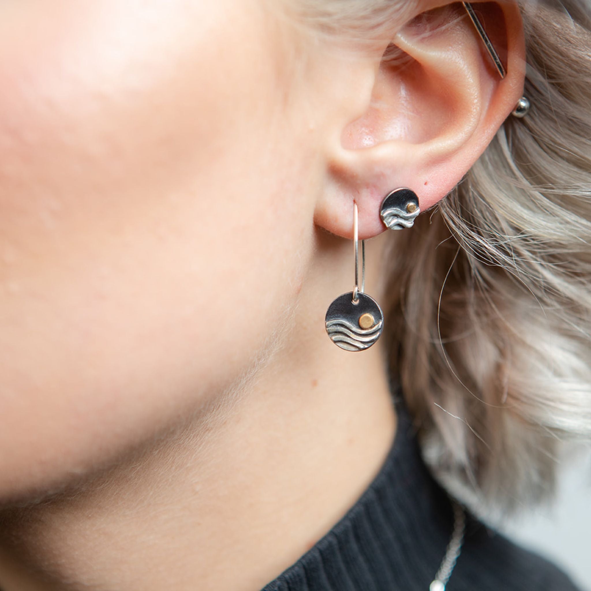 Closeup of model wearing oxidized reflections stud earrings