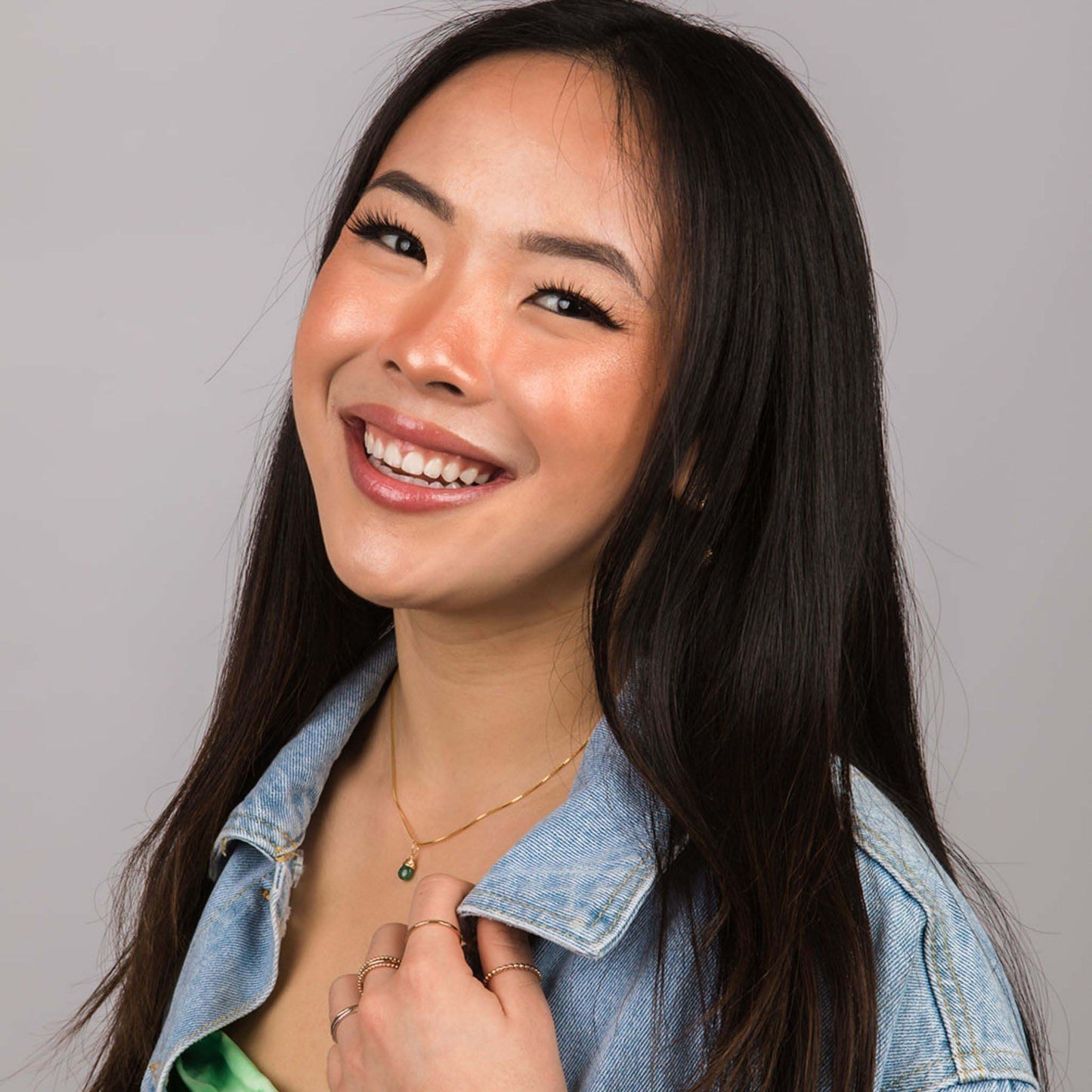 Model wearing May emerald gold birthstone necklace