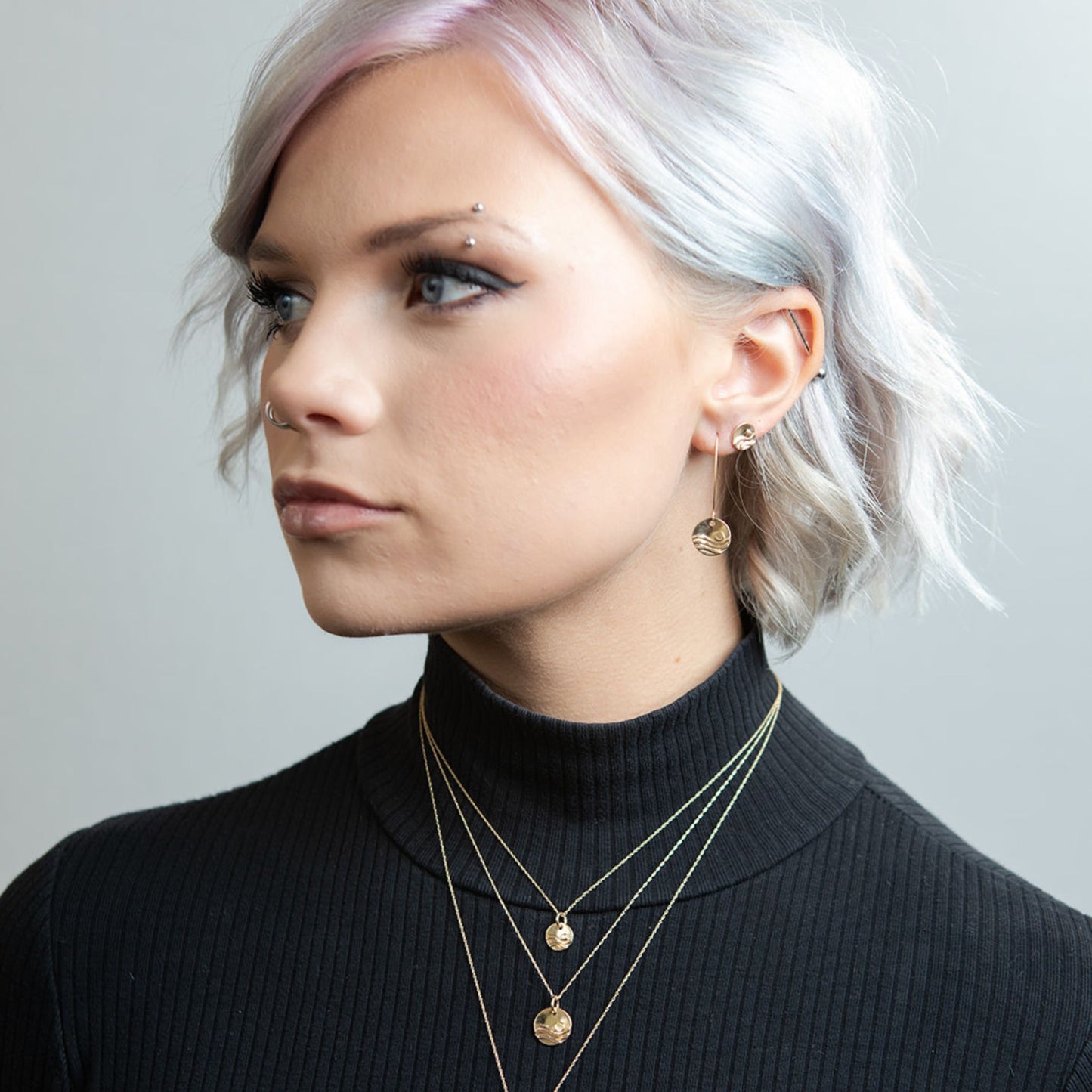 Model wearing gold reflections wave earrings