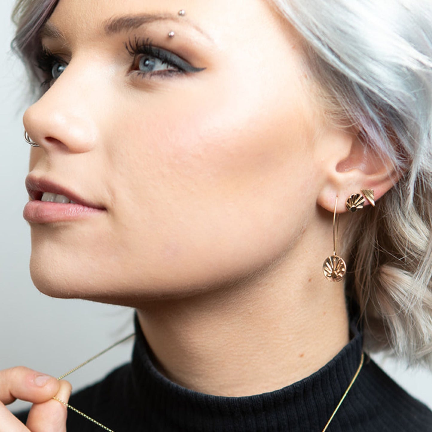 Model wearing gold shine stud earrings