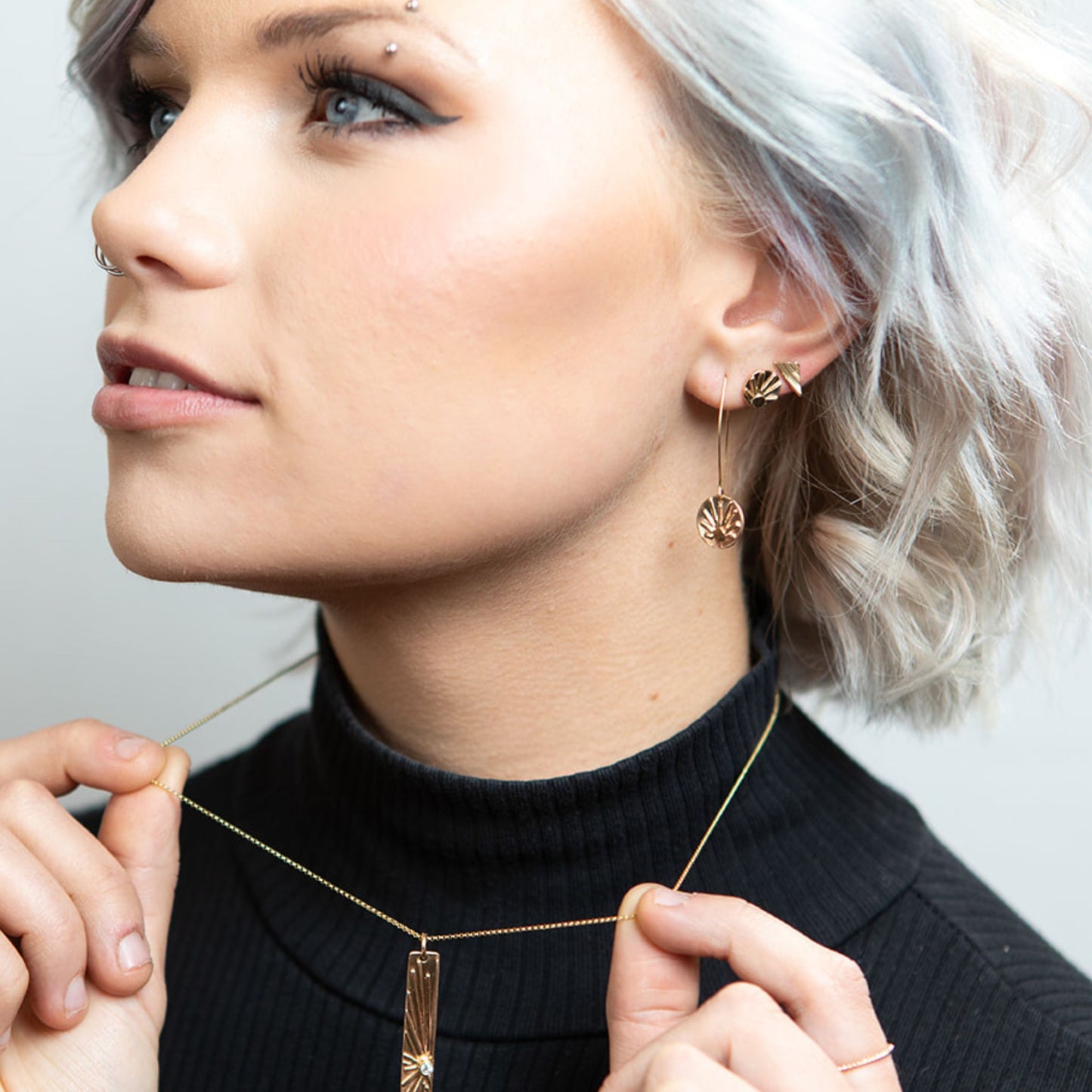 Model wearing gold triangle stud earrings