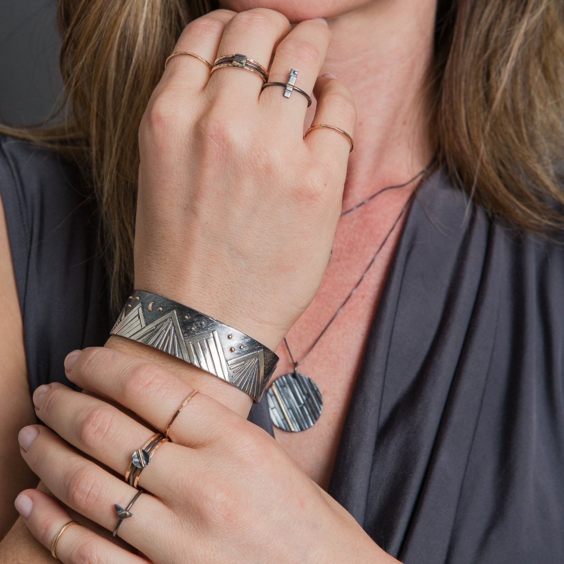 Model wearing mountain bracelet in sterling silver and gold 