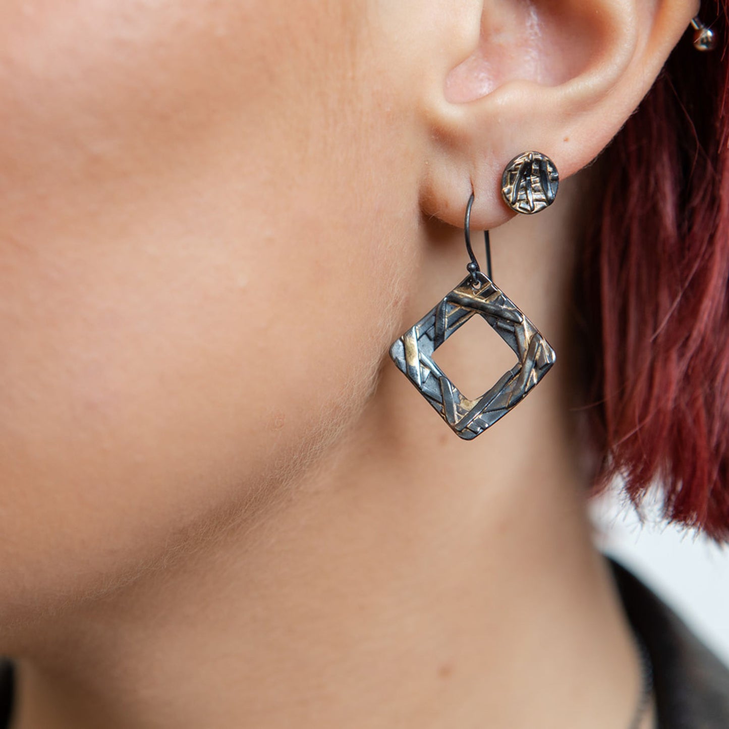 Square washer mixed metal earrings close up on model